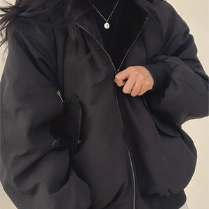 Oversized women's black bomber puffer jacket featuring a trendy winter fashion design with a high collar, long sleeves, and a relaxed fit.