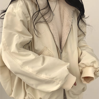 Oversized women's black bomber puffer jacket with a trendy winter fashion design, featuring a high collar, long sleeves, and a quilted pattern, styled on a model with visible shoulder and arm details.