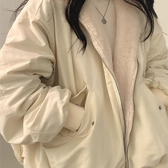 
A fashion model wearing an oversized women's black bomber puffer jacket, styled with trendy winter fashion elements. The jacket features a prominent collar and structured shoulders, paired with a dress shirt underneath. The model poses confidently, accessorized with sunglasses, showcasing the 2XL size variant in a white color.