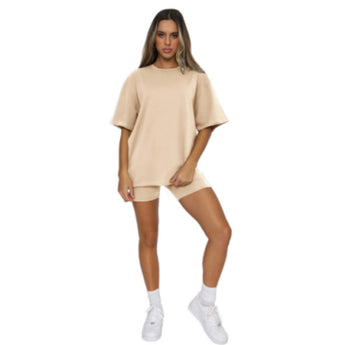 Woman wearing an oversized black cotton t-shirt with a casual loose fit, knee-length, standing with a smile, showing sleeves and thigh area.