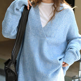 Overhead view of an oversized women's blue knit sweater featuring a deep V-neck design, ideal for cozy winter wear. The sweater is displayed in blue and available in one size, highlighting its stylish and comfortable fashion appeal.