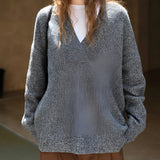 Oversized women's blue knit sweater with a deep V-neck, featuring long sleeves and a cozy fit suitable for winter wear.