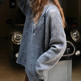 Oversized women's blue knit sweater with a deep V-neck design, featuring long sleeves and a cozy, relaxed fit ideal for winter wear.