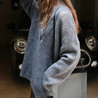 Oversized women's blue knit sweater with a deep V-neck design, featuring long sleeves and a cozy, relaxed fit ideal for winter wear.