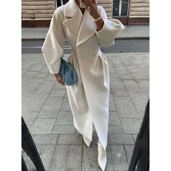 Oversized women's wool trench coat in a double-breasted design, featuring a classic collar and long sleeves. The elegant winter coat has a tailored waist and a stylish, sophisticated appearance.