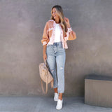 Peach lace blouse paired with acid wash jeans and white sneakers, styled with a grey bag, highlighting a chic summer outfit.