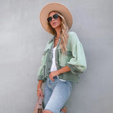 Peach lace blouse paired with acid wash jeans, complemented by white sneakers. Model accessorized with a stylish fedora hat and sunglasses, showcasing a chic summer outfit.