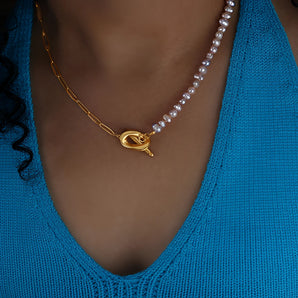 Elegant two-tone pearl gold pendant necklace with a heart clasp, displayed on a neck.