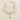 Pearl necklace with gold starfish and seashell charms, elegant beach jewelry displayed on a neutral background.