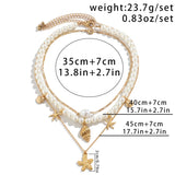 Elegant pearl necklace featuring gold starfish and seashell charms, perfect beach-themed jewelry with intricate details and a delicate chain.