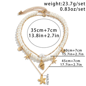 Elegant pearl necklace featuring gold starfish and seashell charms, perfect beach-themed jewelry with intricate details and a delicate chain.