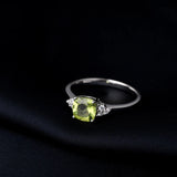 Sterling silver ring with a cushion cut green peridot gemstone and diamond accents.