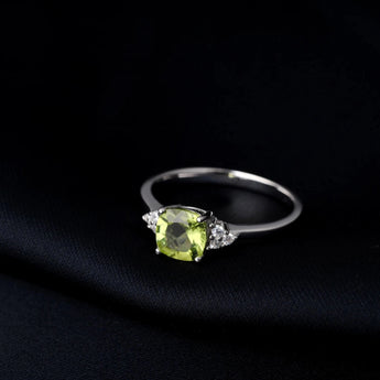 Sterling silver ring with a cushion cut green peridot gemstone and diamond accents.