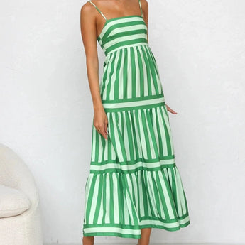 Pink and blue striped maxi dress with spaghetti straps, designed for a summer beach setting; the dress features a flowing one-piece silhouette with emphasis on the shoulder, neck, and waist areas.