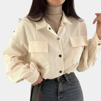 
A beige cropped V-neck blouse with puffed sleeves, designed for a casual chic style. The blouse is displayed on a mannequin, highlighting the short sleeves that puff slightly at the shoulders and the tailored fit around the waist.
