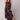 A wide-leg jumpsuit featuring a pink floral bohemian design with pockets, shown on a model. The jumpsuit has short sleeves and a flattering waistline, ideal for casual or day wear. The model is accessorized with a hat and footwear, complementing the bohemian style.