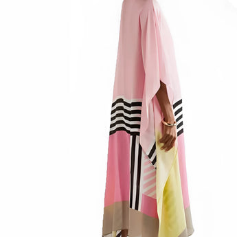 A pink geometric cape dress featuring long sleeves, an asymmetric design, and a flowing silhouette, suitable for evening wear. The dress highlights the shoulder and waist with its unique fashion design, extending to the thigh.