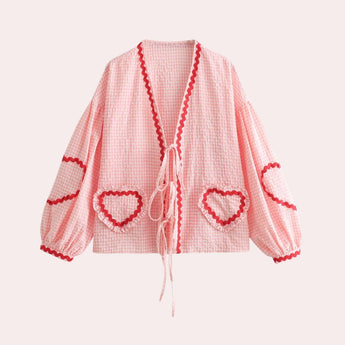 A light pink gingham puff sleeve blouse with ruffle trim, featuring a plaid pattern, suitable for spring fashion in size XL.