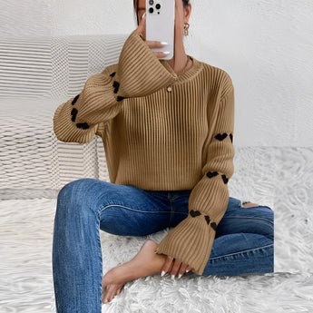 A cozy pink sweater with heart sleeves, perfect for fall fashion, featuring a comfortable pullover design and modeled by a person showing shoulder and hairstyle details.
