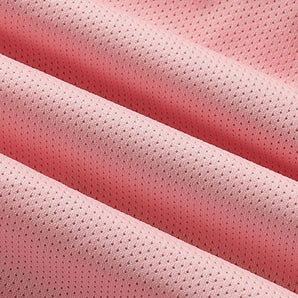 Close-up image of pink lightweight moisture-wicking athletic wear fabric, showcasing its soft texture and subtle pattern. The fabric features various pink shades, including magenta and peach tones.