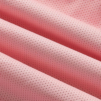 Close-up image of pink lightweight moisture-wicking athletic wear fabric, showcasing its soft texture and subtle pattern. The fabric features various pink shades, including magenta and peach tones.