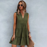 Sleeveless pink linen tiered mini dress with a V-neck design, styled for summer fashion.