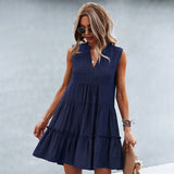 Sleeveless pink linen tiered mini dress with a V-neck design, worn by a woman with shoulder-length hair and sunglasses, showcasing a stylish summer fashion look.