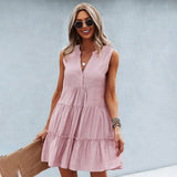 Sleeveless pink linen tiered mini dress with a V-neck design, worn by a smiling woman.
