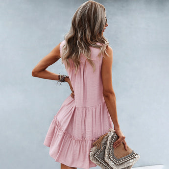 Sleeveless pink linen tiered mini dress with a V-neck, perfect for summer fashion.