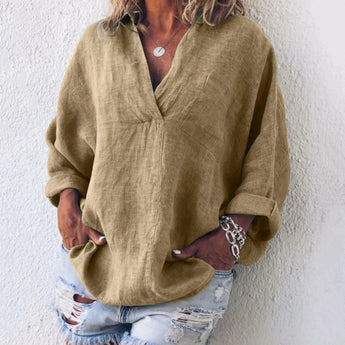 
An oversized V-neck blouse in a soft pink hue, designed for women, featuring a relaxed fit with long sleeves and made from lightweight linen fabric, styled as a casual spring top.