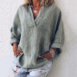 Pink oversized V-neck linen blouse for women, showcasing a relaxed fit, suitable for spring, paired with jeans, featuring long sleeves and a comfortable textile.