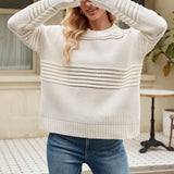 Pink textured ribbed sweater with a cut-out design, worn by a person with medium-length hair. The sweater is in an XL size and styled with a modern knitwear look, featuring a high neckline and long sleeves. The color is predominantly pink with a hint of white.