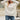 Pink textured ribbed sweater with a cut-out design, worn by a person with medium-length hair. The sweater is in an XL size and styled with a modern knitwear look, featuring a high neckline and long sleeves. The color is predominantly pink with a hint of white.