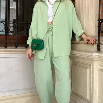 Women's pink trouser suit set including a blazer, high-waist pants, and a crop top, displayed on a white background.