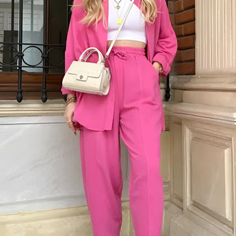 Women's pink trouser suit set including a blazer, high-waist pants, and a crop top.