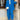 Woman wearing a blue high-waist pants, blazer, and crop top set, standing and posing.