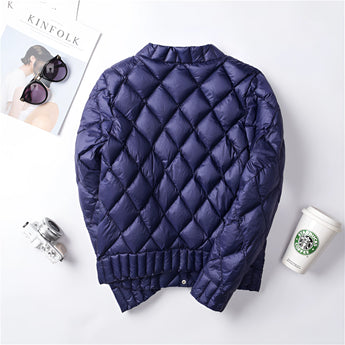
A pink women's lightweight quilted jacket featuring a diamond pattern with long sleeves, displayed against a neutral background.