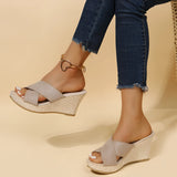 Pink women's espadrille wedge sandals with suede strap and ankle chain displayed on a model's foot, highlighting the combination of casual style with elegant detailing.