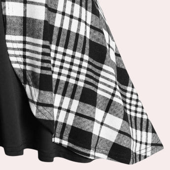 Black and white checkered plaid dress with long sleeves and a knee-length hem, featuring a collar.