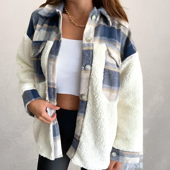A woman wearing a blue plaid Sherpa jacket with fleece lining, featuring long sleeves and a cozy collar, suitable for winter fashion.