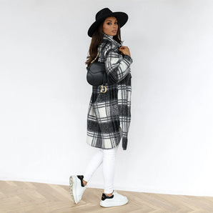 Oversized monochrome plaid wool blend shacket featuring a belted waist, long sleeves, and a wide collar, paired with a stylish fedora hat.
