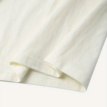 Plain white unisex t-shirt with short sleeves and a round collar, minimalist design shown on a beige background.