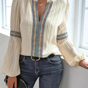 Vintage-styled V-neck pleated blouse with ribbon detail, featuring long sleeves and a chic design.