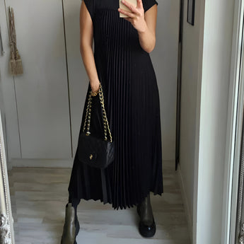 Pleated maxi dress in taupe with cap sleeves, designed for summer wear. The dress features a flowing, one-piece silhouette and a defined waist, suitable for a formal or casual setting. The image shows the dress with a Nero color and in 3XL size, highlighting the elegant fashion style.