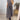 Pleated maxi dress in taupe with cap sleeves, worn by a woman accessorized with sunglasses; the dress features a fitted waist and flows elegantly to the knees, suitable as a summer women's day dress in a gray 3XL size.
