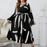 Plus size abstract print midi dress featuring long sleeves and a tie waist, suitable for party attire.
