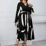Plus size abstract print midi dress with long sleeves, tie waist, and suitable for party attire, showing shoulder, neck, waist, knee, and thigh areas.