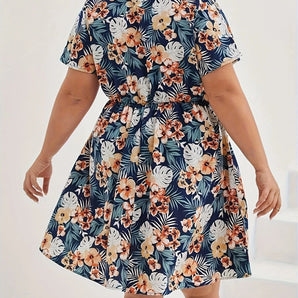 Plus size knee-length summer dress with blue floral tropical print, featuring short sleeves and a round neckline, worn by a model.