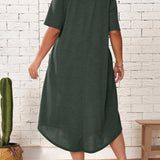 
A woman standing and wearing a plus size green loose fit midi dress, ideal for casual summer wear. The dress features an oversized design with comfortable sleeves and a relaxed waistline, falling to a knee-length.