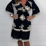 Plus size green V-neck boho summer dress with floral embroidery, featuring short sleeves and a relaxed fit. The dress is styled for a casual, comfortable look.